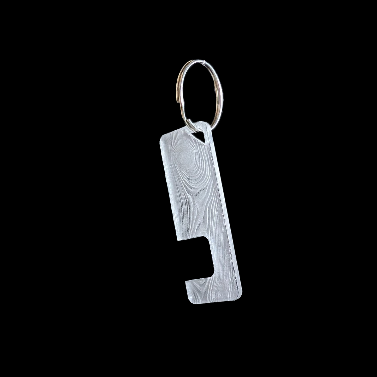 a transparent phone stand key ring with an engraved Wood texture against a black background. Rua phone stand by Fiach Rua